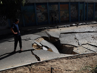 A picture taken early on May 12, 2021 shows a huge crater in main street in Gaza City, following Israeli airstrikes on the Hamas-run territo...