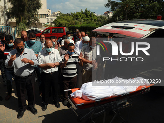 People offer funeral prayers next to the body of a Palestinian, who was killed amid a flare-up of Israeli-Palestinian violence, in Gaza City...