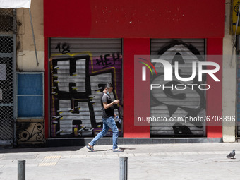 A man seen walking past a closed store at the center of Athens, Greece on May 15, 2021. (