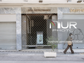 A woman seen walking past a closed store at the center of Athens, Greece on May 12, 2021. (