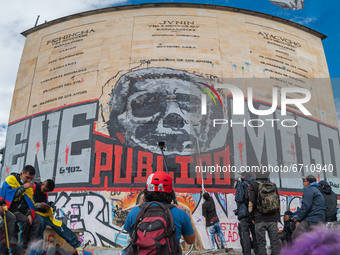 A panoramic shot of a mural against former president Alvaro Uribe Velez with his face that reads 