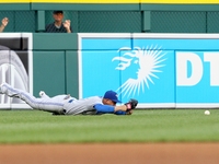 Toronto Bluejays' Ezequiel Carrera lands on the field in a failed attempt to catch the ball hit by Detroit Tigers' Nick Castellanos of a bas...