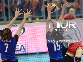 Miyu Nagaoka (Top) of Japan spikes the ball as Thailand players attemp to block during their FIVB World Grand Prix intercontinental round ma...