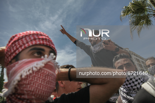 A demonstrator on top of a protester's shoulders, gestures and shouts anti-Israel slogans during a demonstration held by thousands of Tunisi...