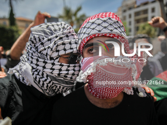 Protesters wearing the Palestinian keffiyeh attend a demonstration held by thousands of Tunisian an Palestinian demonstrators on avenue Habi...