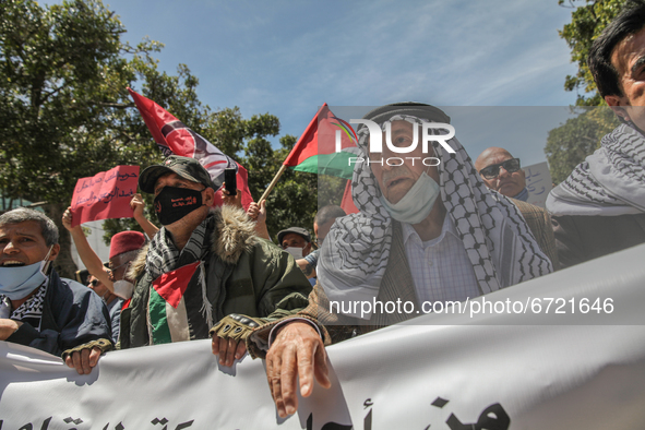 Protesters wearing the Palestinian keffiyeh shout anti-Israel slogans as they wave Palestinian flags during a demonstration held by thousand...