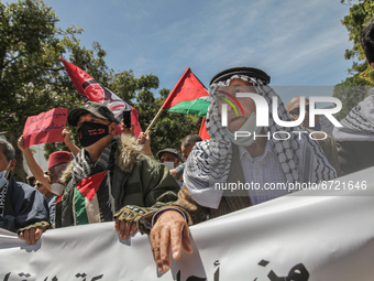 Protesters wearing the Palestinian keffiyeh shout anti-Israel slogans as they wave Palestinian flags during a demonstration held by thousand...