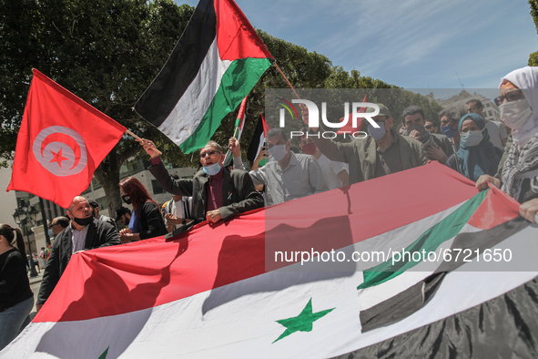 Protesters wave Tunisian, Palestinian and Syrian flags as they shout anti-Israel slogans during a demonstration held by thousands of Tunisia...