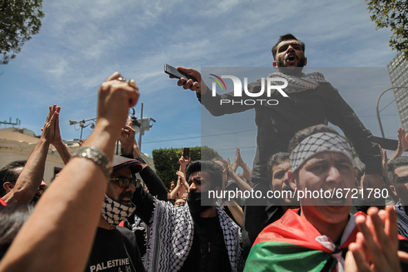 A demonstrator on top of a protester's shoulders, gestures and shouts anti-Israel slogans as other protesters raise their fists during a dem...