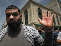 A protester shows his hand stained with blood after being injured by security forces during a demonstration held by thousands of Tunisian an...