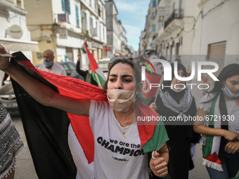 Female protesters wearing the Palestinian flag shout anti-Israel slogans during a march held on the street in the capital Tunis, Tunisia, on...