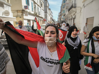 Female protesters wearing the Palestinian flag shout anti-Israel slogans during a march held on the street in the capital Tunis, Tunisia, on...