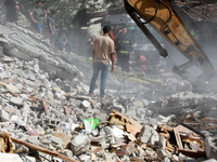An excavator clears the rubble of a building, after it was struck by Israeli strikes, in Gaza City, May 16, 2021. - Israeli forces pummeled...