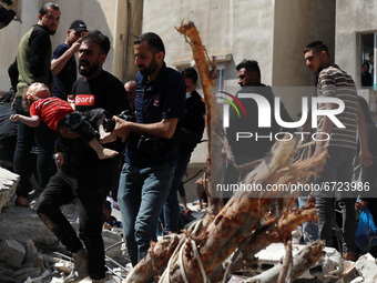 (EDITOR'S NOTE: Image depicts death) Palestinians recover the body of a child from the rubble of a destroyed building in Gaza City's Rimal r...