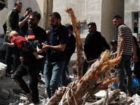 (EDITOR'S NOTE: Image depicts death) Palestinians recover the body of a child from the rubble of a destroyed building in Gaza City's Rimal r...
