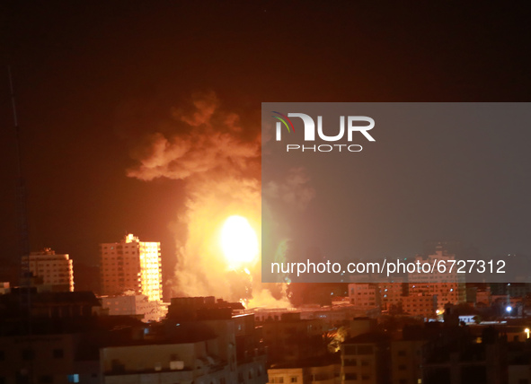 A ball of fire and a plume of smoke rise above buildings in Gaza City as Israeli forces shell the Palestinian enclave, early on May 17, 2021...