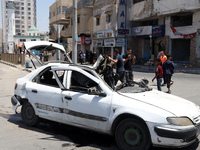 Palestinians inspect a car that was hit by an Israeli airstrike, near the beach in Gaza City, Monday, May 17, 2021. (