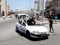 Palestinians inspect a car that was hit by an Israeli airstrike, near the beach in Gaza City, Monday, May 17, 2021. (