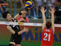 Miyu Nagaoka (L) of Japan spikes the ball as Serbia player attemp to block during their FIVB World Grand Prix intercontinental round match a...