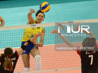 Juciely Cristina Barreto (Top) of Brazil spikes the ball as Thailand players attemp to block during their FIVB World Grand Prix intercontine...