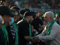 Yahya Sinwar (R), leader of the Palestinian Hamas movement, shakes hands with Hamas leaders during a rally in Gaza City on May 24, 2021. (