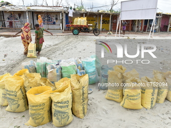 Women seen carrying filled sand bags which will be used as a temporary support  to their house roofs living adjacent to the coastal area whe...