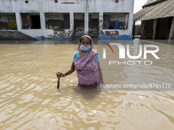 A old woman with a stick to figure out the roads as all of them are submerged in floodwater due to river embankments have broken and several...