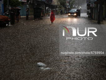 A woman walks on the street in the rain at morning in Dhaka, Bangladesh on June 01, 2021. Heavy monsoon downpour causes extreme water loggin...