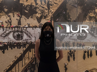 LONDON, UNITED KINGDOM - JUNE 02, 20201: A woman poses with 'Migrants, Mayra, Picnic across the Border, Tecate, Mexico—U.S.A.' (2017) by JR...