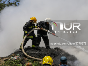 Smoke rises as firefighters try to douse a fire on a pile of wires at the premises of Waste Management Section in Kathmandu, Nepal on June 3...