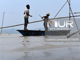 Fishermen installing a fishing net in a bamboo structure to fish in the Brahmaputra river, in Guwahati, Assam, India on Thursday, 03 June 20...