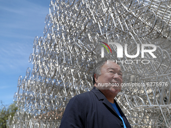 Chinese artist Ai Weiwei poses in front of his sculpture 