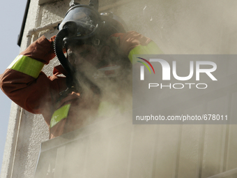 Firefighters try to contain a fire that broke out at residential area in Tokyo, July 8, 2015.  (
