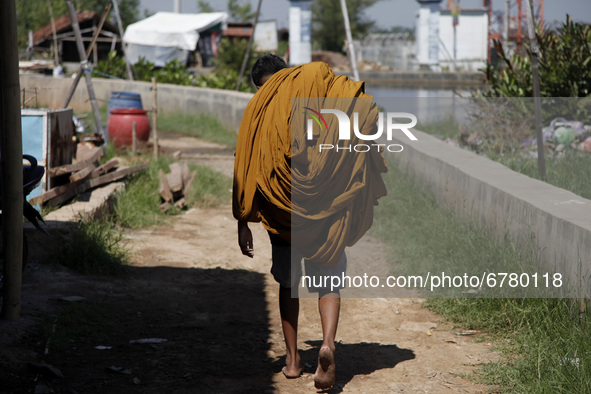 A man carry the colored batik cloth to be wash in Asem Binatul river flow, in Pekalongan, Central Java province, on June 4, 2021. According...