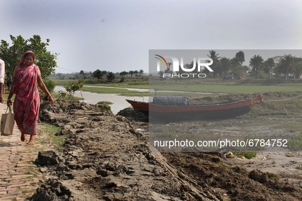 A woman posed  in front of a broken embankment after Cyclone YAAS from regular tides while many embankments remain damaged in Kulpi , Kolkat...
