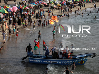 Palestinian members of Gaza's Bar Woolf sports team perform fire breathing on the beach as an entertainment for children in Gaza City on Jun...