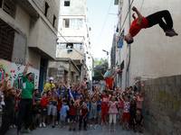 Palestinian members of Gaza's Bar Woolf sports team perform during a sports show as an entertainment for children at the Beach refugee camp,...