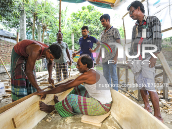 Boatbuilders make small wooden boats at the Thulthulia Bazar in Demra on June 9, 2021, as they fear that the low-lying areas might get flood...