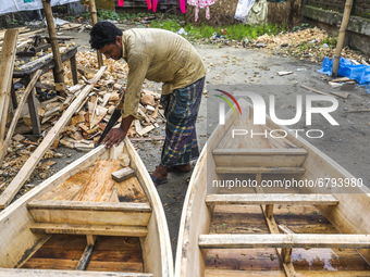 Boatbuilders make small wooden boats at the Thulthulia Bazar in Demra on June 9, 2021, as they fear that the low-lying areas might get flood...
