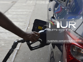 A fuel pump worker puts the fuel nozzle inside the fuel  tank of a car in Kolkata, India, 10 June, 2021. Petrol price in Kolkata is Rs 95.52...