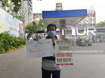 A man protests with placards due to the fuel hike in Kolkata, India, 10 June, 2021. Petrol price in Kolkata is Rs 95.52 per litre and Diesel...