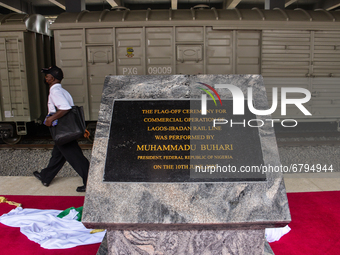 A commuter walks past a commissioned marble granite engraved plaques at the  newly commissioned Mobolaji Johnson Railway Station in Ebutemet...