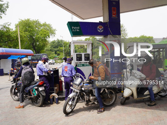 A fuel station attendant pumps petrol into a two wheeler during a protest against rising fuel prices of Petrol and Diesel, at a filling stat...