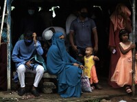 People take shelter during a light rain as they came to visit a park on holiday and cannot maintain social distancing amid the covid-19 pand...