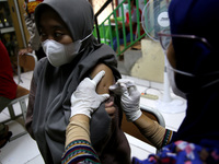 Health workers inject vaccinations for ages eighteen and over and people with disabilities in a school room in Duren Sawit, East Jakarta, In...