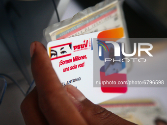 A man holds a United Socialist Party of Venezuela (PSUV) ID card at a registration day, amid the pandemic for Covid-19, downtown, in Caracas...