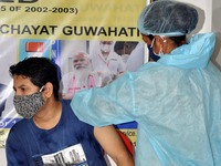 A medic administers a dose of COVID-19 vaccine to a young  person  at a vaccination centre in Guwahati, India on June 12,2021. (