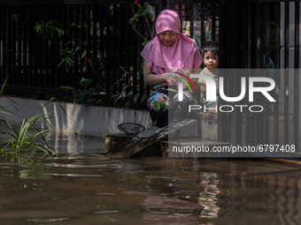 A mother and her child in front of their house waiting for the flood to subside.. Floods that hit Nerada Estate housing, Cipayung, Ciputat,...