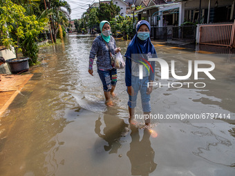 Mother and daughter bring lunch to their flooded house. Floods that hit Nerada Estate housing, Cipayung, Ciputat, South Tangerang (Tangsel)...