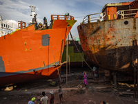 Dockyard workers carry on maintenance works on the hull of a ship on the bank of the Buriganga River in Dhaka, Bangladesh on June 13, 2021....